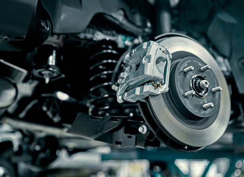 Close-up of a car's brake system and suspension components, highlighting their design and functionality.